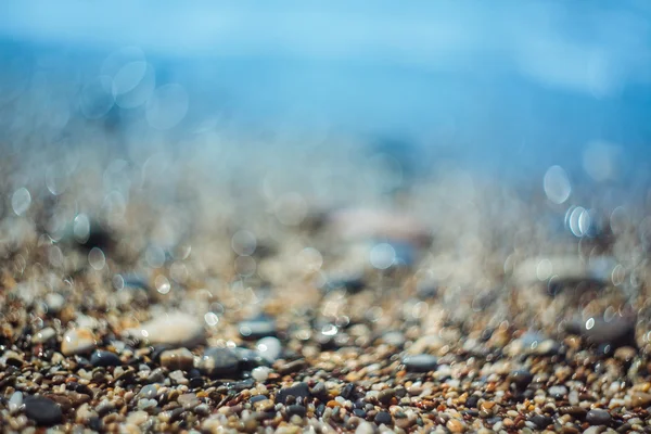 Фон с галькой и синим морем — стоковое фото