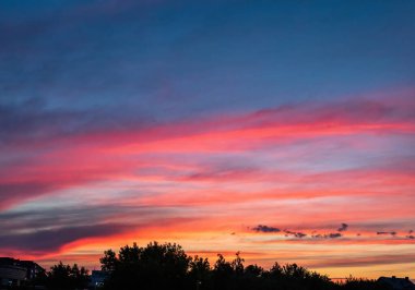 Gün batımında turuncu ve mor gökyüzünde güzel kırmızı bulutlar
