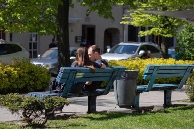 Vilnius, Litvanya - 14 Mayıs 2017: Litvanya 'nın Vilnius kentindeki Vokieciu caddesinde mavi bankta oturan genç çift.