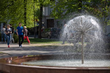 Vilnius, Litvanya - 14 Mayıs 2017: İnsanlar Litvanya 'nın Vilnius kentindeki Vokieciu caddesindeki ferahlatıcı çeşmenin önünden geçtiler. Çeşmeye odaklan.. 