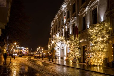 Vilnius, Litvanya - 13 Aralık 2020: Vilnius eski kasabasının Picturesque Didzioji sokağı, Noel zamanı için güzelce aydınlatılmış.