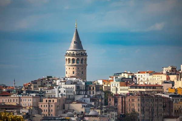 İstanbul, Türkiye - 4 Ekim 2025: Güneşli bir sonbahar öğleden sonrasında, Ortaçağ 'a ait tarihi bir taş yapı olan Galata Kulesi, Beyoğlu' nun çatılarından yükseliyor..