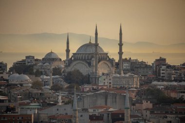 İstanbul, Türkiye - 6 Ekim 2025: Görkemli Nurosmaniye Camii (Nurosmaniye Camii), arka planda Marmara Denizi üzerinde puslu bir günbatımıyla tarihi gökyüzünde görülüyor.