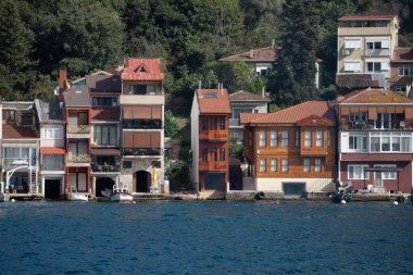 İstanbul, Türkiye - 5 Ekim 2025: Geleneksel, renkli ahşap Yali (rıhtım) evleri ve konutları doğrudan Boğaz boğazının kıyısında duruyor.