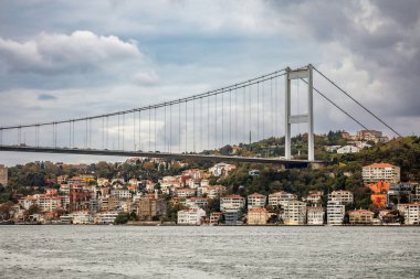 İstanbul, Türkiye - 5 Ekim 2025: Fatih Sultan Mehmet Köprüsü (İkinci Boğaz Köprüsü) kıyıdaki tarihi liman kenarı yali villaları üzerindeki boğazı kaplıyor.
