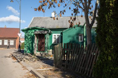 Telsiai, Litvanya - 18 Ekim 2025: Eski mimarinin tipik bir yerleşim alanı olan Telsiai 'de, desenli tahta çatılı geleneksel küçük bir ahşap ev duruyor.