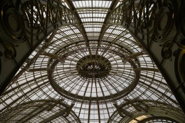 Paris, Fransa - 14 Kasım 2025: Tarihi Palais 'in içindeki Nave' in ikonik cam ve çelik kubbesinin ve fıçı ile döşenmiş çatısının alçak açılı görüntüsü.