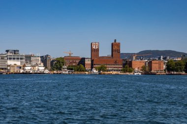 Oslo, Norveç - 17 Temmuz 2025: Oslo Belediyesi 'nin ikonik kırmızı tuğla kuleleri limandan görülen ufuk çizgisine her yıl düzenlenen Nobel Barış Ödülü törenine ev sahipliği yapıyor..