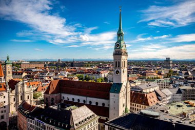 Münih, Almanya - 21 Eylül 2023: Alter Peter olarak bilinen St. Peters Kilisesi 'nin tarihi kulesi, Bavyera' da mavi bir gökyüzünün altında eski şehrin çatılarından yükseliyor..