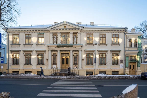 Klaipeda, Litvanya - 2 Şubat 2026: Liepu Caddesi 'ndeki Saat Müzesi' nin (Laikrodziu Muziejus) neoklasik cephesi, güneşli bir kış gününde heykeller ve güneş saati.