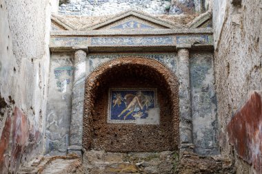 Pompeii, İtalya - 5 Kasım 2022: Küçük Çeşme Evi 'nde cam mozaikler ve kabuklarla süslenmiş iyi korunmuş antik Roma duvar çeşmesi.