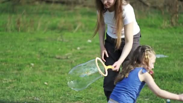 Дівчата роблять бульбашки в парку — стокове відео