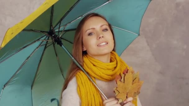 Woman with leaves and umbrella — Stock Video