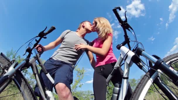 Pareja sosteniendo bicicletas y besándose — Vídeos de Stock