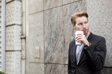 Genç adam kahve içiyor.