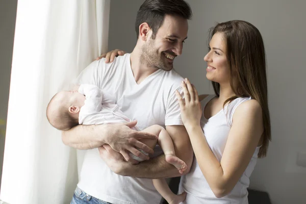 Lycklig familj vid fönstret — Stockfoto