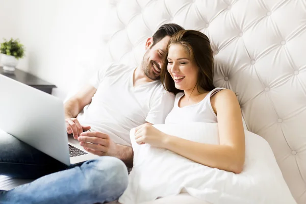 Met laptop in het bed (echt) paar — Stockfoto