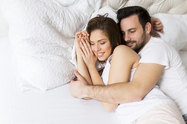 Pareja joven en la cama — Foto de Stock