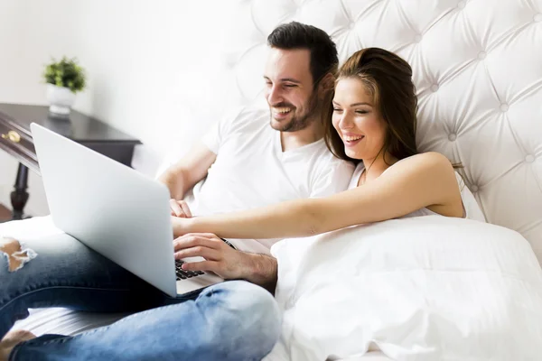 Par med laptop i sängen — Stockfoto