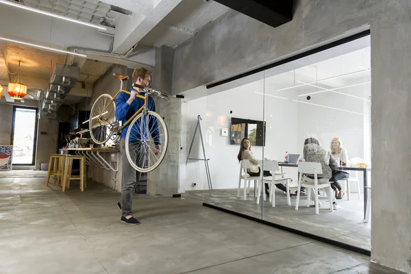 Człowiek z rowerem w biurze — Zdjęcie stockowe