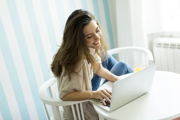 Mujer joven con un ordenador portátil — Foto de Stock