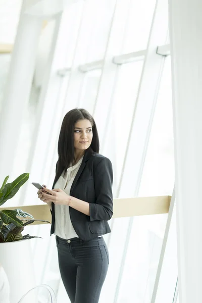 携帯電話を持った若い女性が — ストック写真