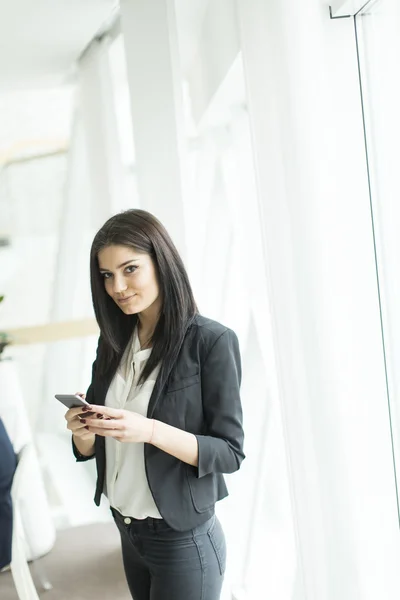 携帯電話を持った若い女性が — ストック写真