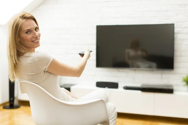 Mulher com um controle remoto tv — Fotografia de Stock