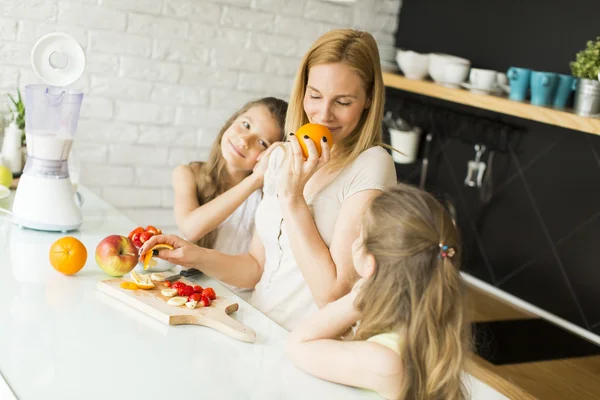 Frau und zwei Mädchen in der Küche — Stockfoto