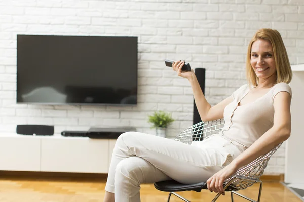 Mulher com um controle remoto tv — Fotografia de Stock