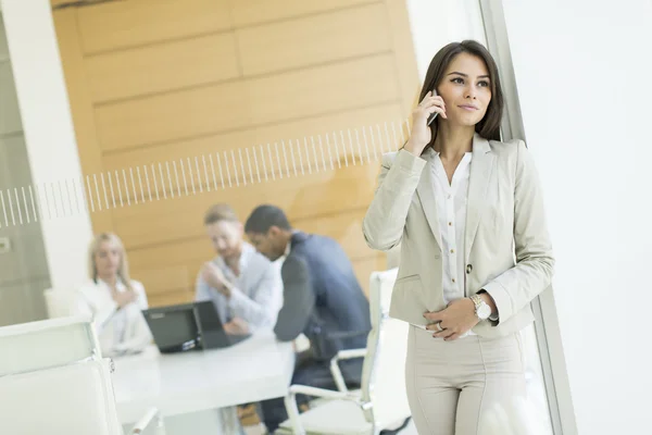 Geschäftsfrau mit Telefon im Büro — Stockfoto