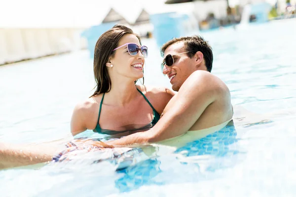 Pareja joven en la piscina — Foto de Stock