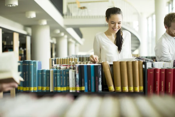 Ung kvinna i biblioteket — Stockfoto