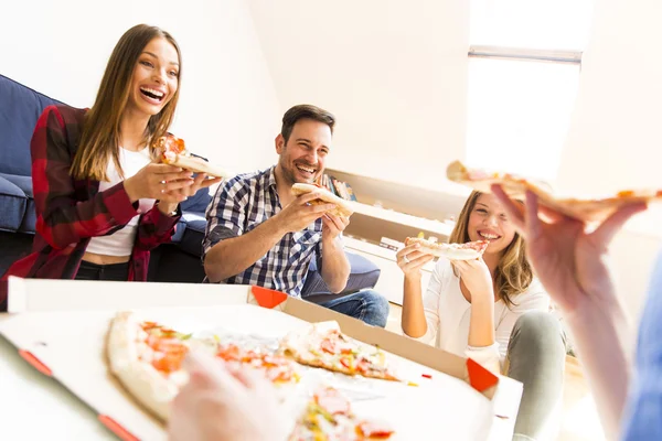 Jóvenes comiendo pizza en la habitación — Foto de Stock