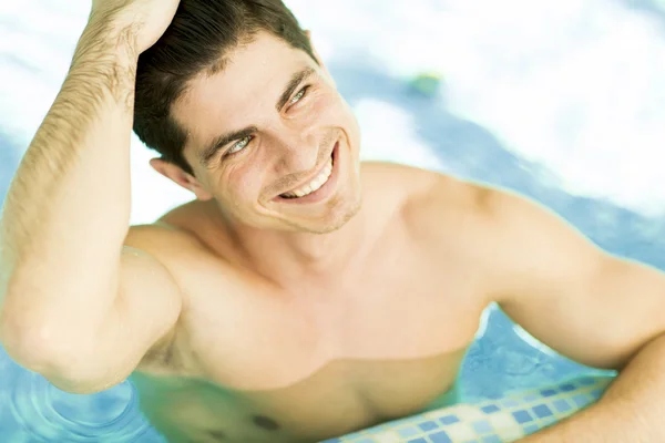Mladý muž relaxuje v bazénu — Stock fotografie