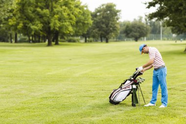 Golf oynayan genç adam.