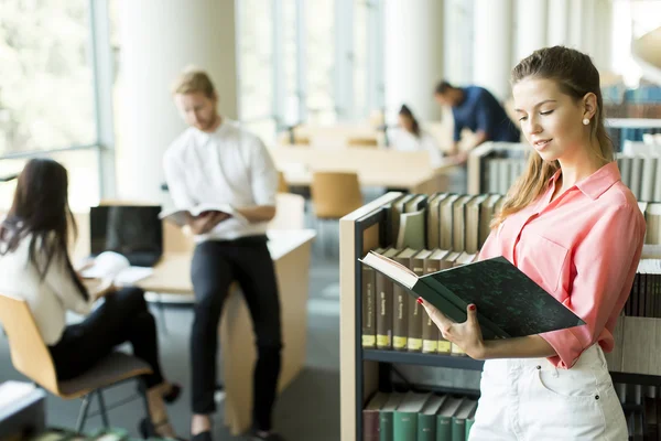 Ung kvinna i biblioteket — Stockfoto