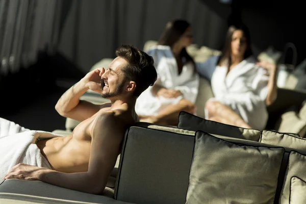 Mladý muž v sauně s mobilní hone — Stock fotografie