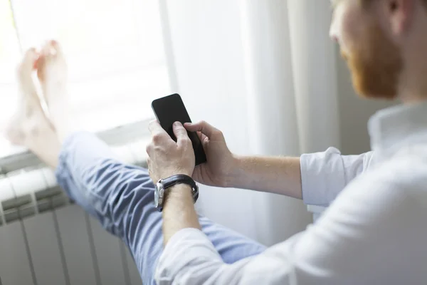 Pelirrojo hombre con teléfono en la habitación —  Fotos de Stock