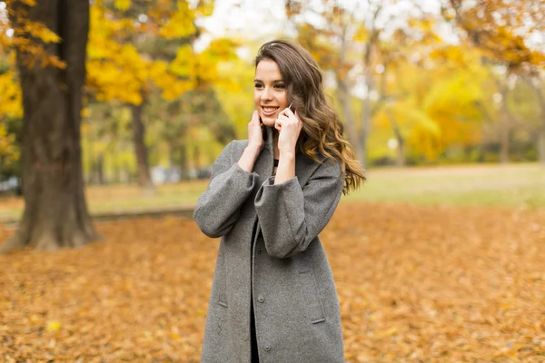 Jonge vrouw in het herfstpark — Stockfoto