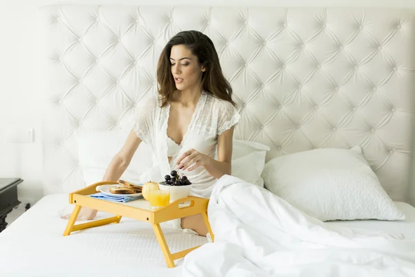 Jolie jeune femme prenant un petit déjeuner — Photo