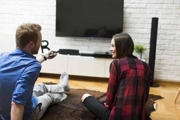 Pár koukání na televizi doma — Stock fotografie