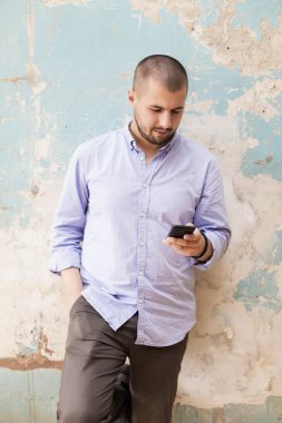 Akıllı telefonu olan genç bir adam.