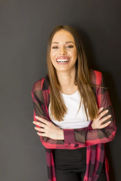 Young woman by the wall — Stock Photo, Image