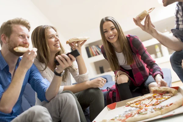 Друзья едят пиццу в комнате — стоковое фото