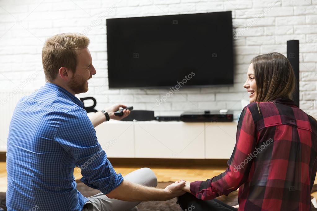 Couple watching tv at home