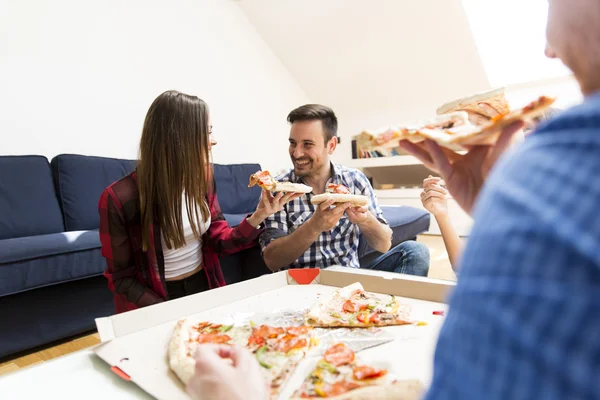 Jovens comendo pizza no quarto — Fotografia de Stock