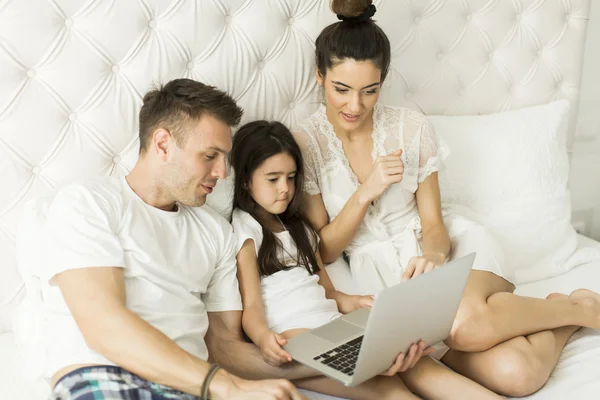 Familia joven en la cama — Foto de Stock