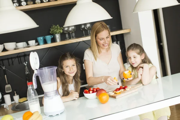 Mother and daughters in the kitchen — Stock Photo, Image