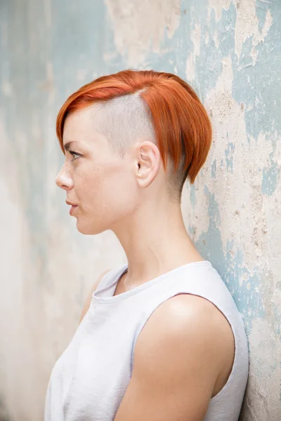 Joven mujer de pelo rojo por la vieja pared —  Fotos de Stock